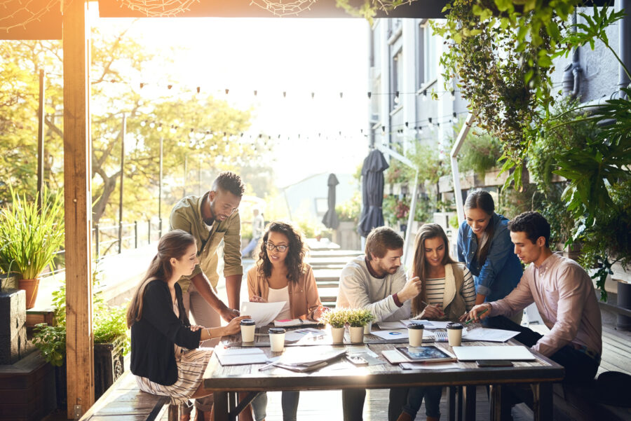 Millennials working together on outdoor patio of coffee shop