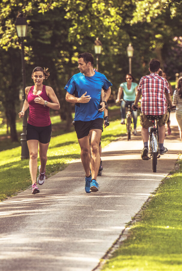 Couple going on a jog together through paved nature trails