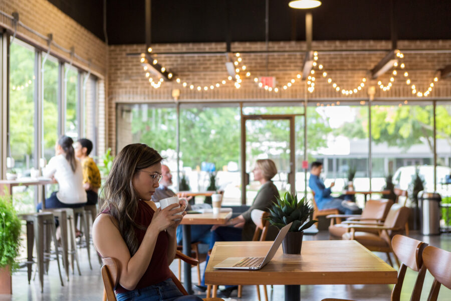 Young woman works on her laptop in a coffee shop