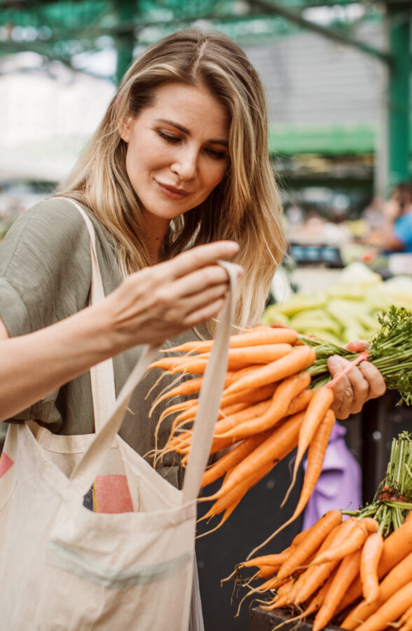 Woman buying groceries at outdoor fresh produce market