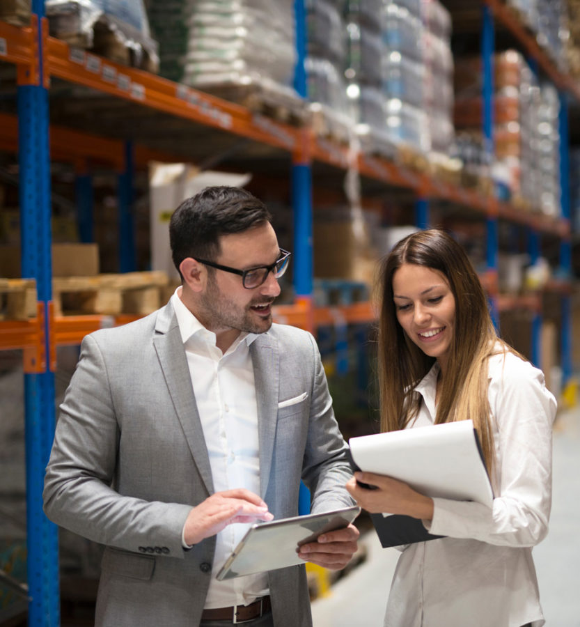 man and woman discussing business in warehouse